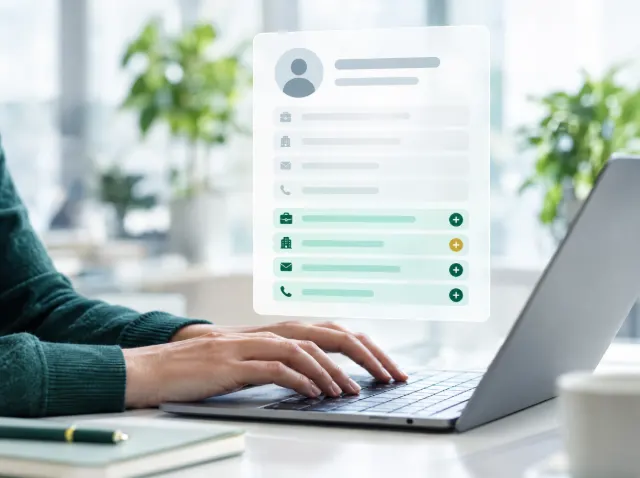 Hands on a laptop with a contact record gaining new job title, company, email and phone fields